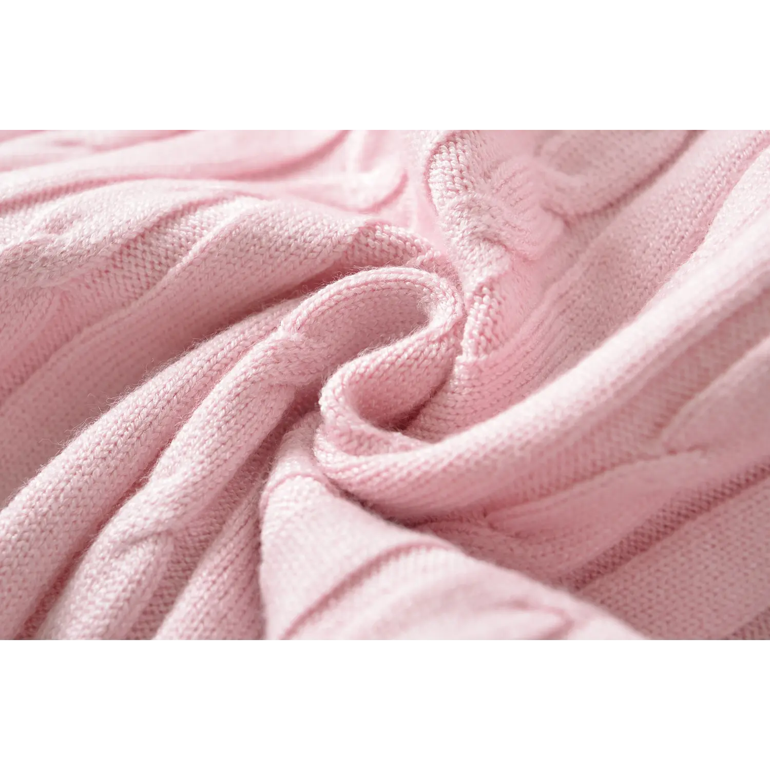 Macro fabric texture shot showing soft cable knit weave of pink sweater