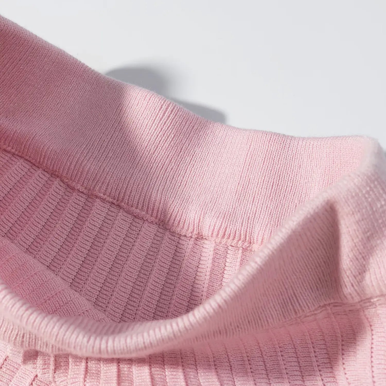 Close‑up interior view of pink sweater scalloped peter pan collar, fine knit stitching and fabric texture