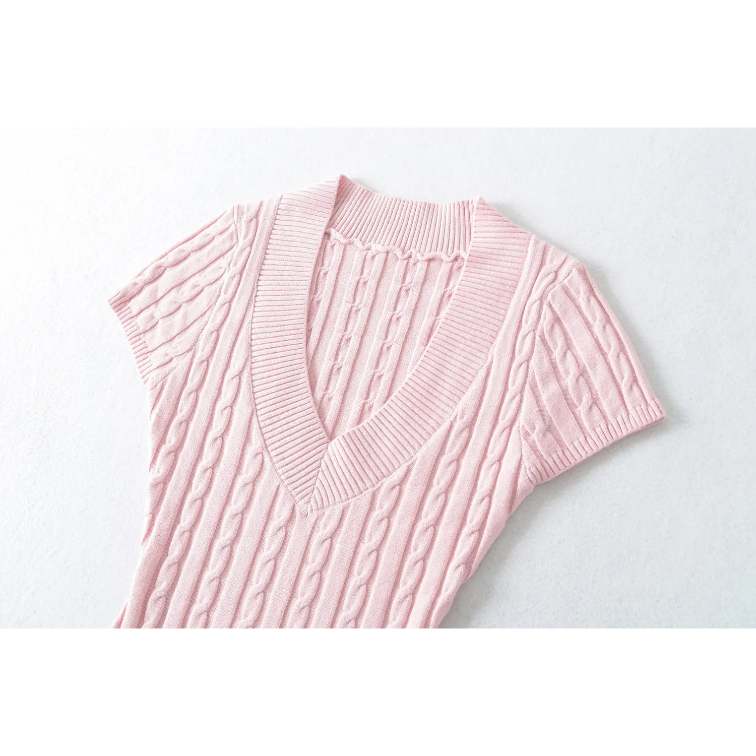 Close‑up shot of v‑neck collar and cable knit texture on pink short sleeve sweater
