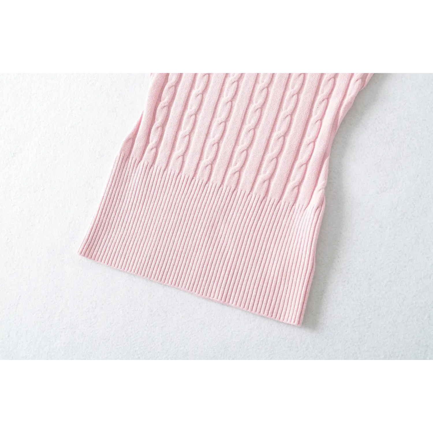 Close‑up of ribbed waist hem on pink v‑neck cable knit short sleeve top
