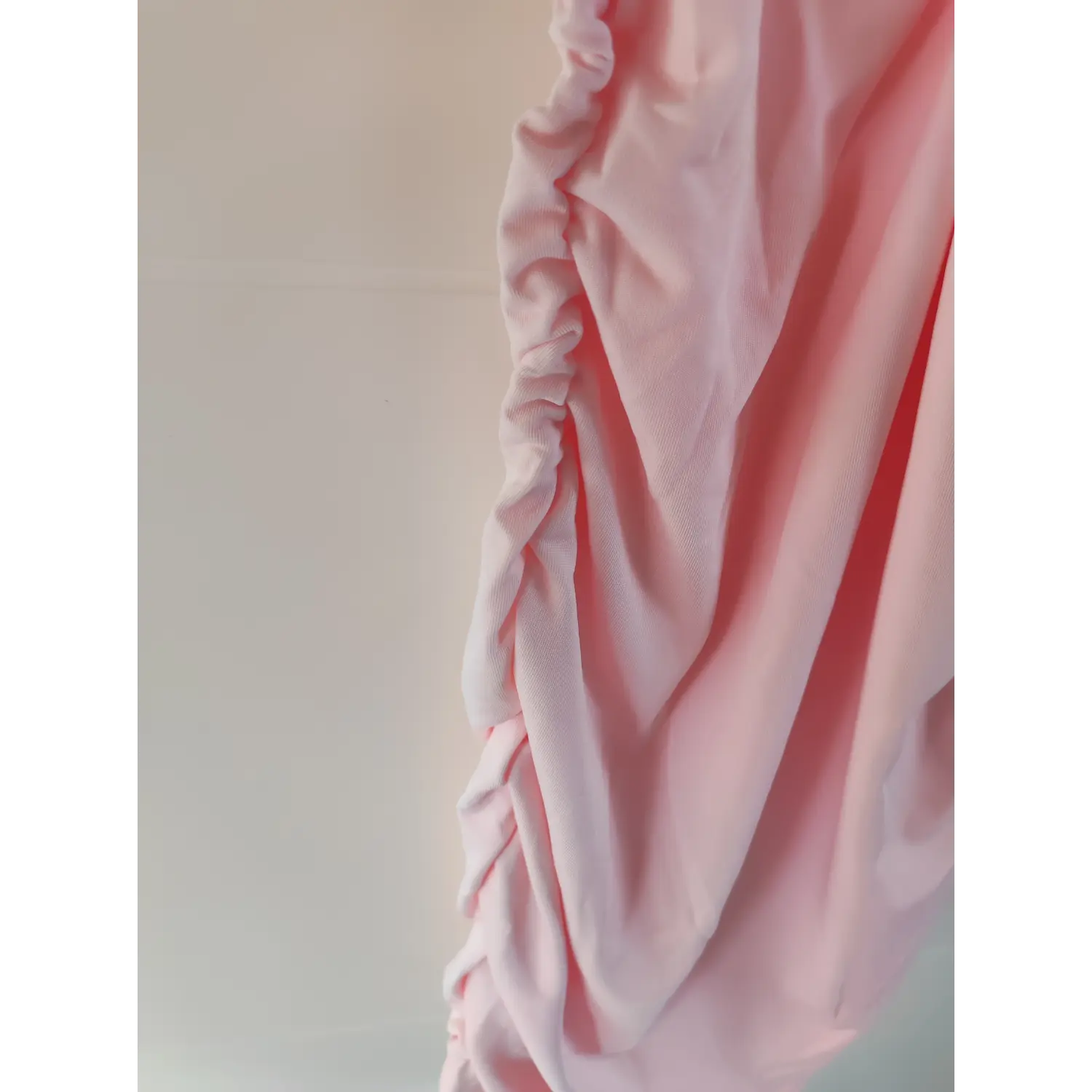 Side close‑up adjustable ruched drawstring fabric detail of pink stretch mini dress