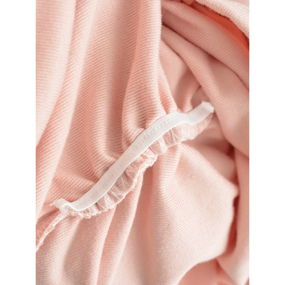 Close-up of the knit fabric on pink cami top, showing texture and elasticated gathered edge.