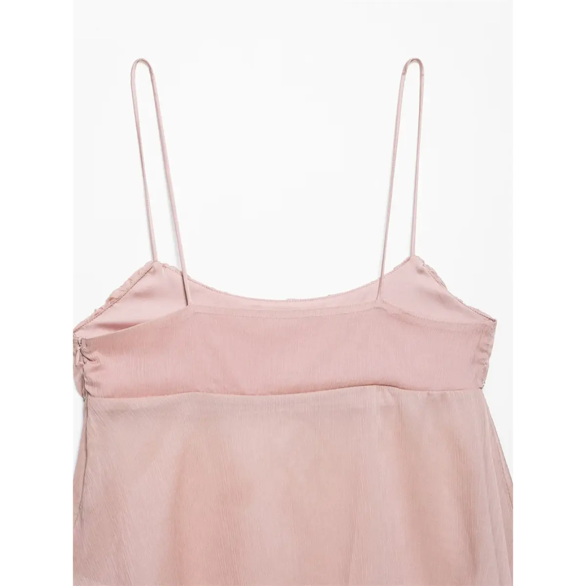 Close-up detail of the upper back of a light pink cami top, showing the spaghetti straps, smooth lining, and gathered construction.
