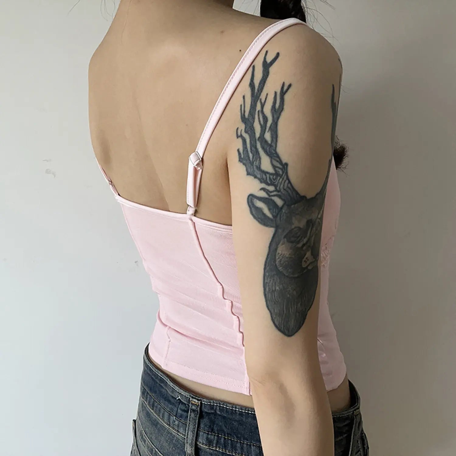 Back side wearing partial shot, adjustable thin shoulder strap detail, plain rear fabric, waist tailored curvy silhouette
