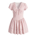 Flat lay pink gingham dress with front bow and tiered ruffle skirt