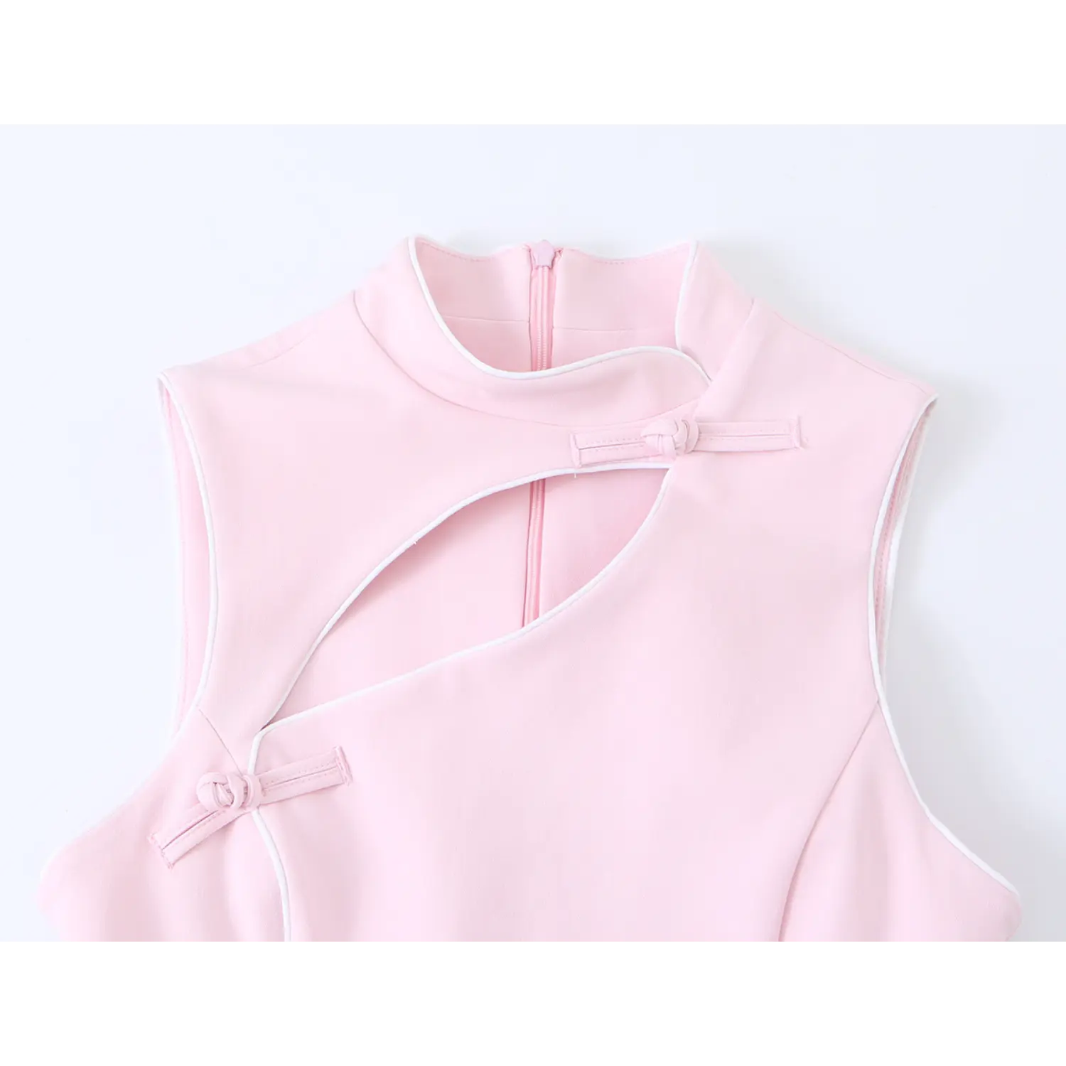 Close-up shot of stand collar and asymmetrical hollow cutout detail on light pink sleeveless qipao dress with white piping trim