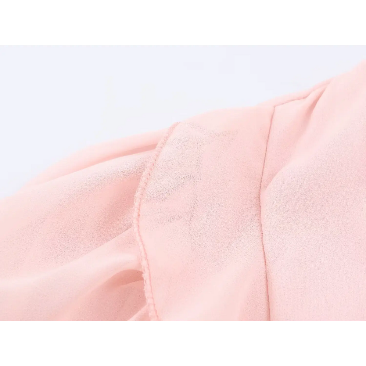 Macro shot of lightweight pink chiffon fabric and raw edge ruffle for maxi dress