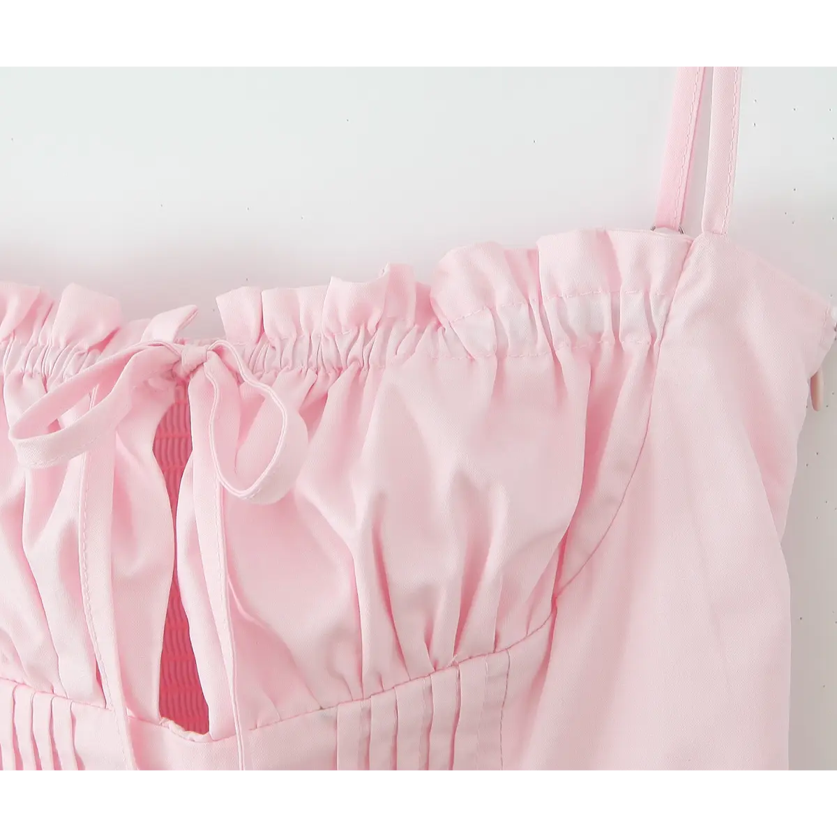 Close-up of center front drawstring tie, gathered fabric, and smocked inner lining.