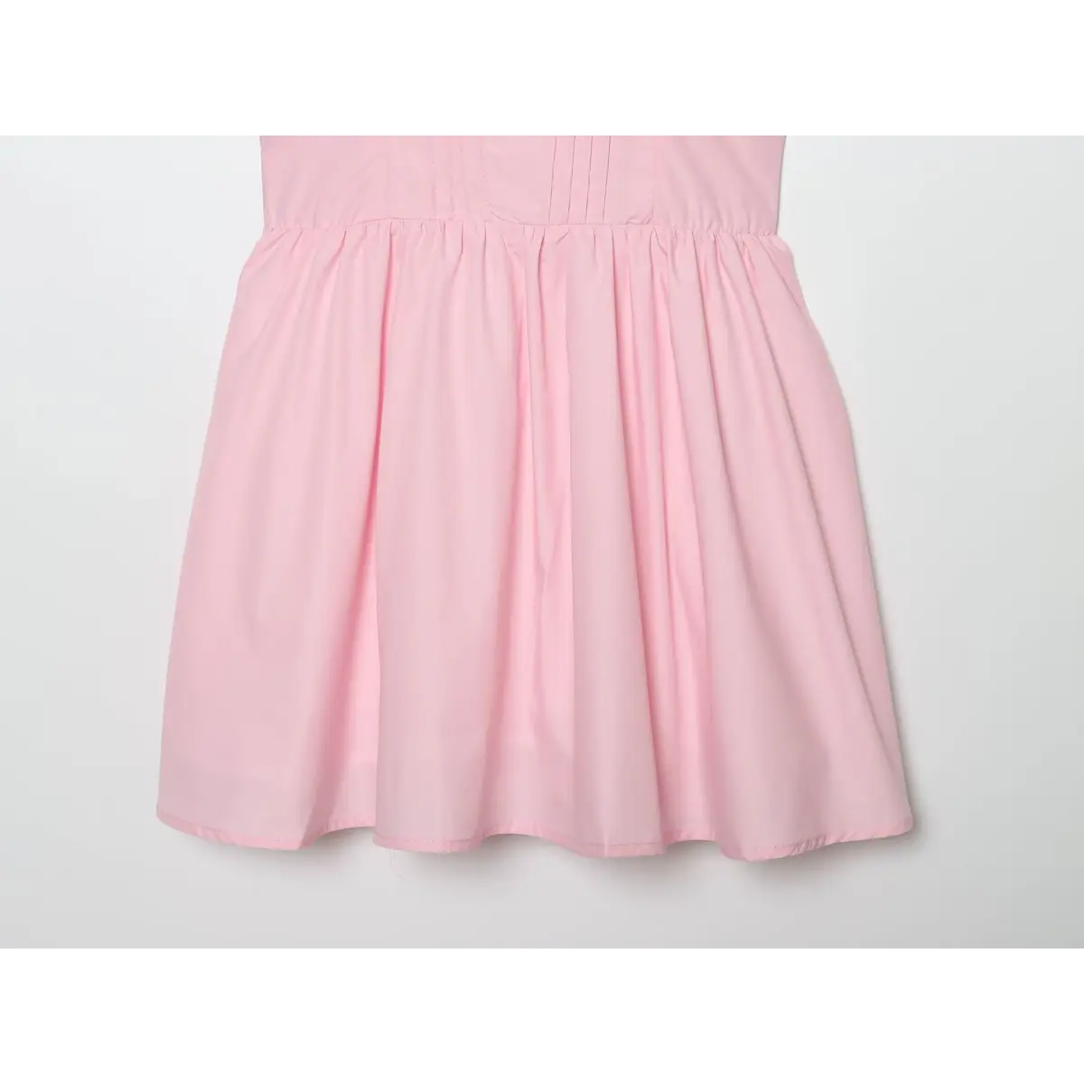 Waist gather close of baby pink sundress, vertical pintuck corset bodice and ruched waist for flowy A-line flare skirt.