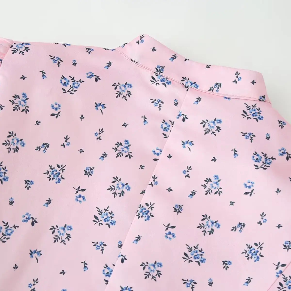 Close-up of the back mandarin collar on the pink ditsy floral blouse, showing the smooth fabric and floral print