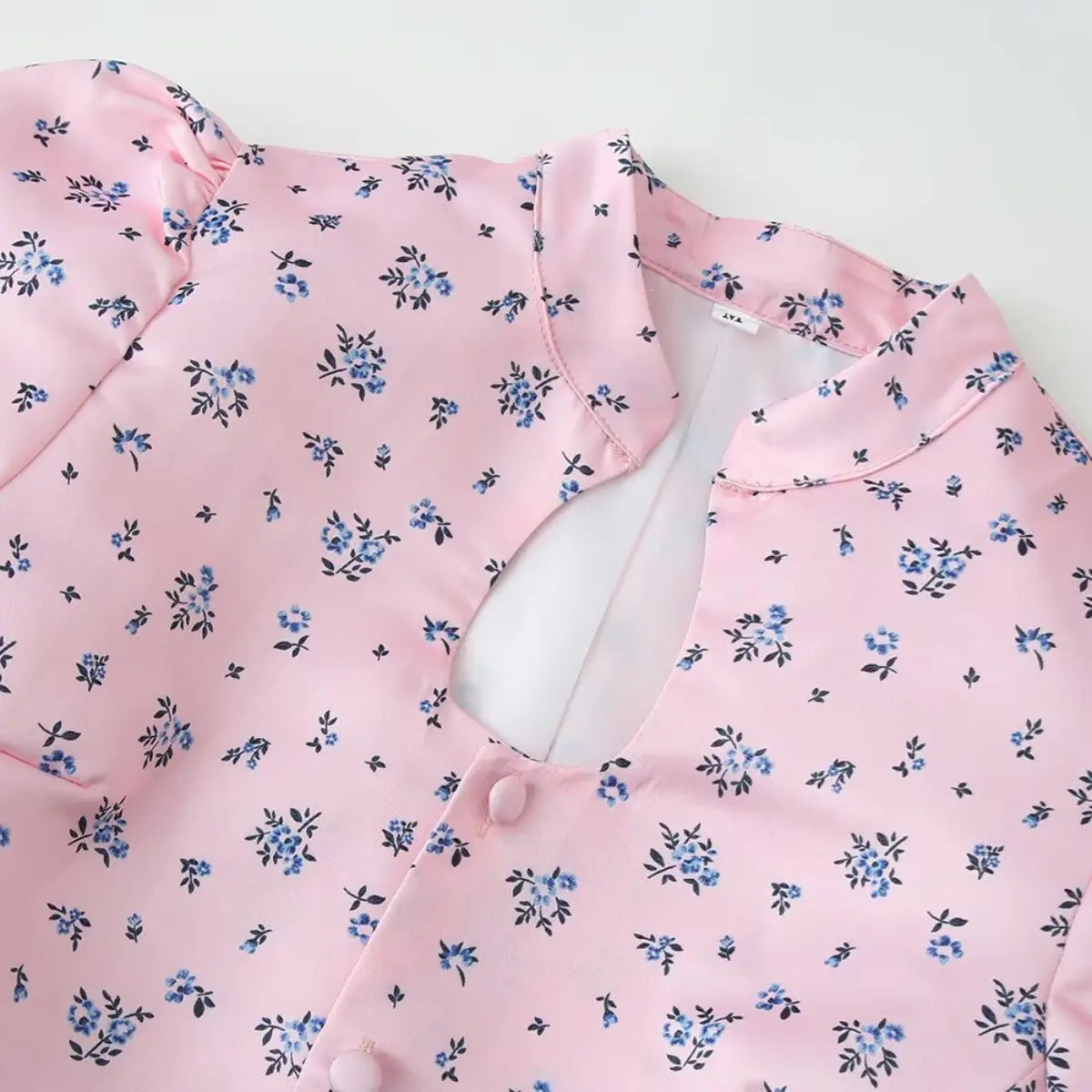 Front view of the pink ditsy floral blouse, showing the keyhole cutout, mandarin collar, and fabric buttons