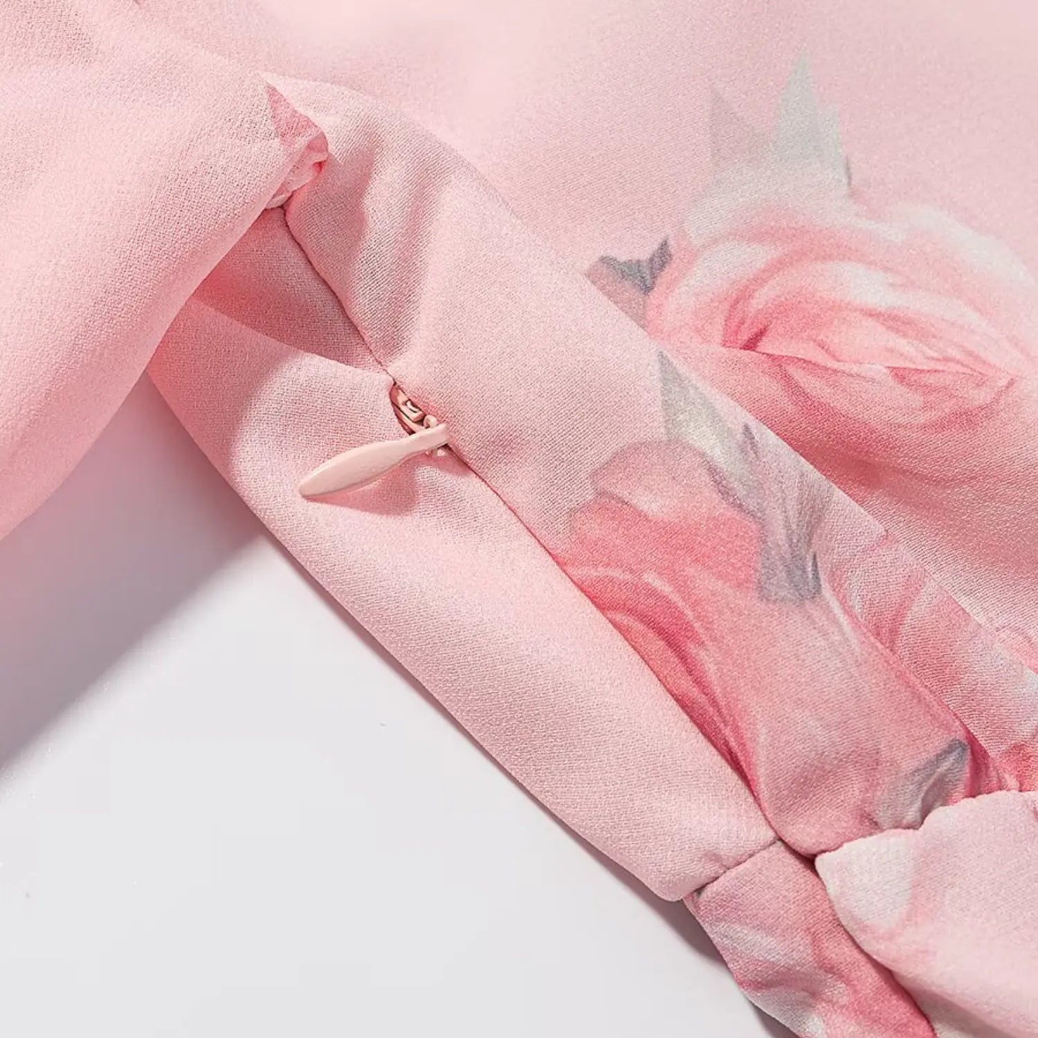 Back center invisible pink zipper macro close-up, matching floral fabric tape, smooth fabric pull tab