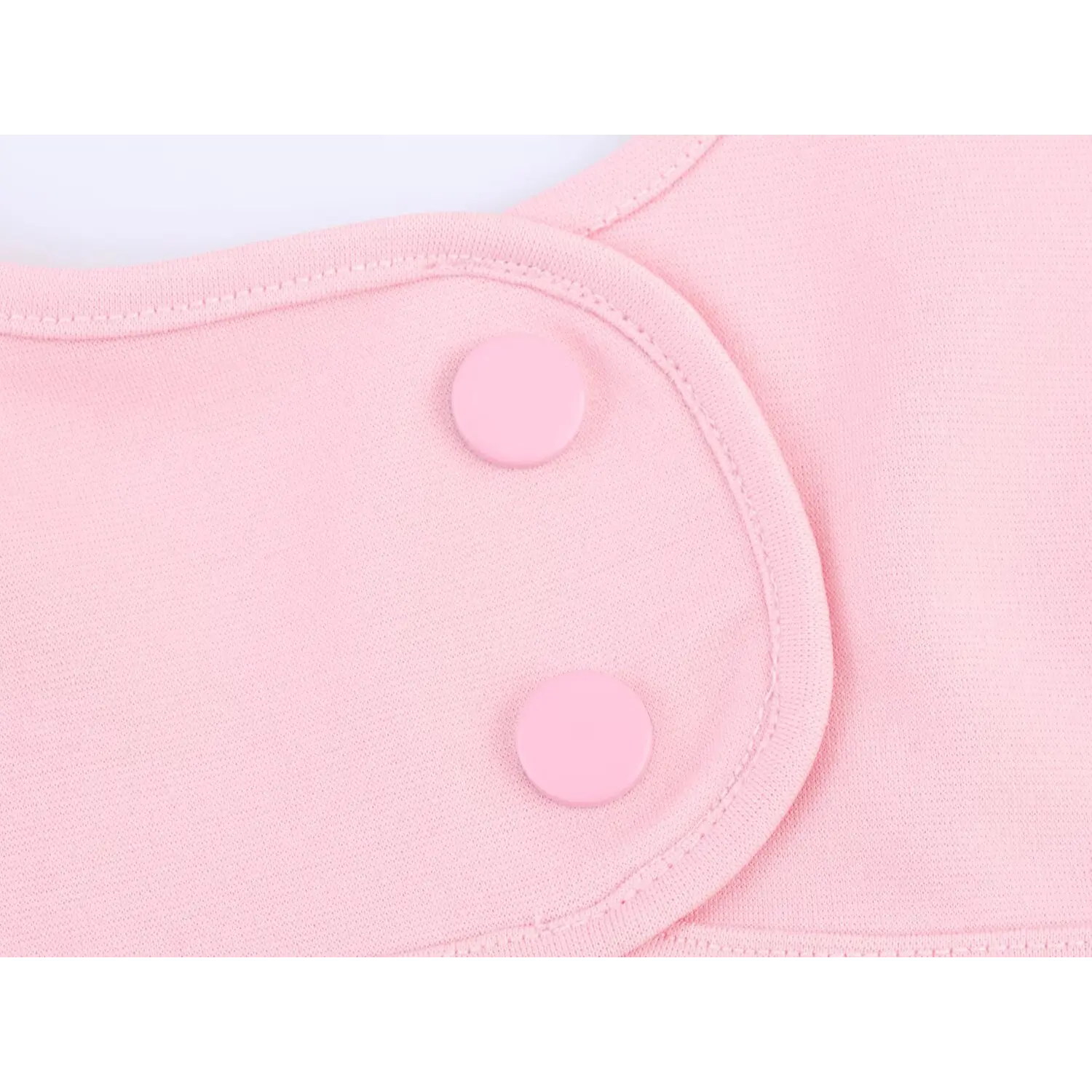 Macro close-up of matching pink decorative round buttons on fabric placket