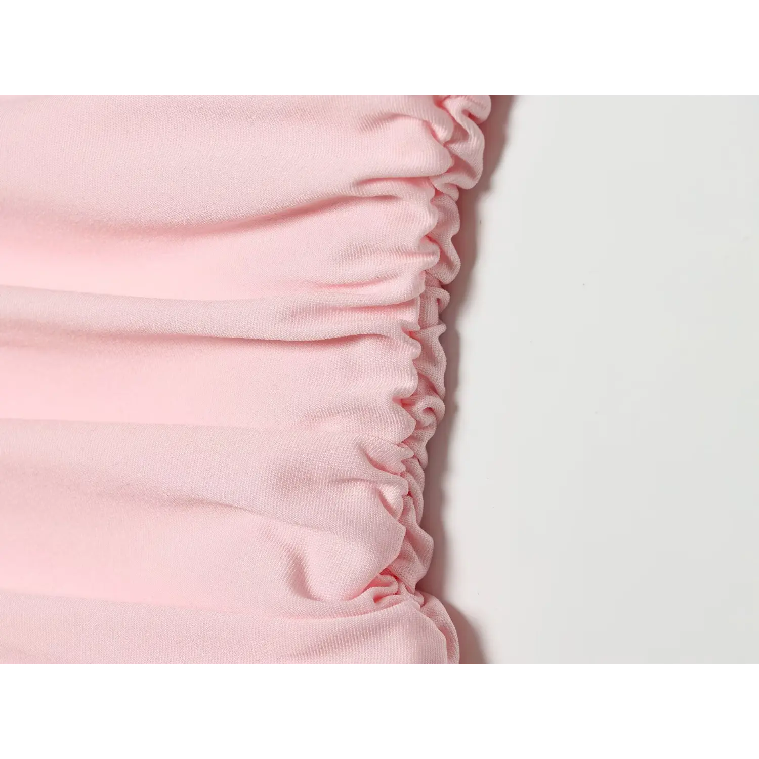 Extreme closeup of side ruched gathering stitching, stretch soft pink fabric for women mini dress