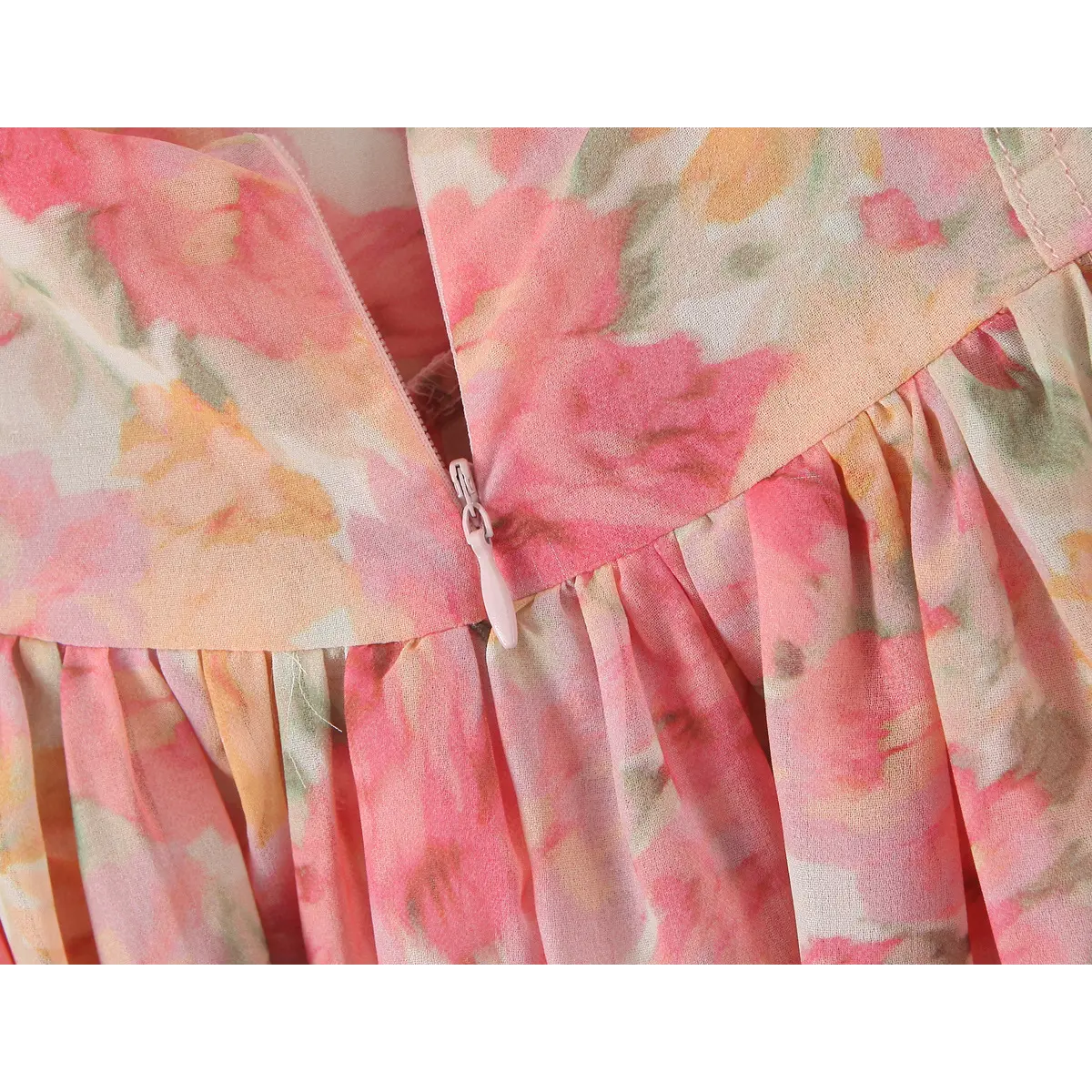 Close-up of the invisible side zipper at the waist seam, with the pink pull matching the print.