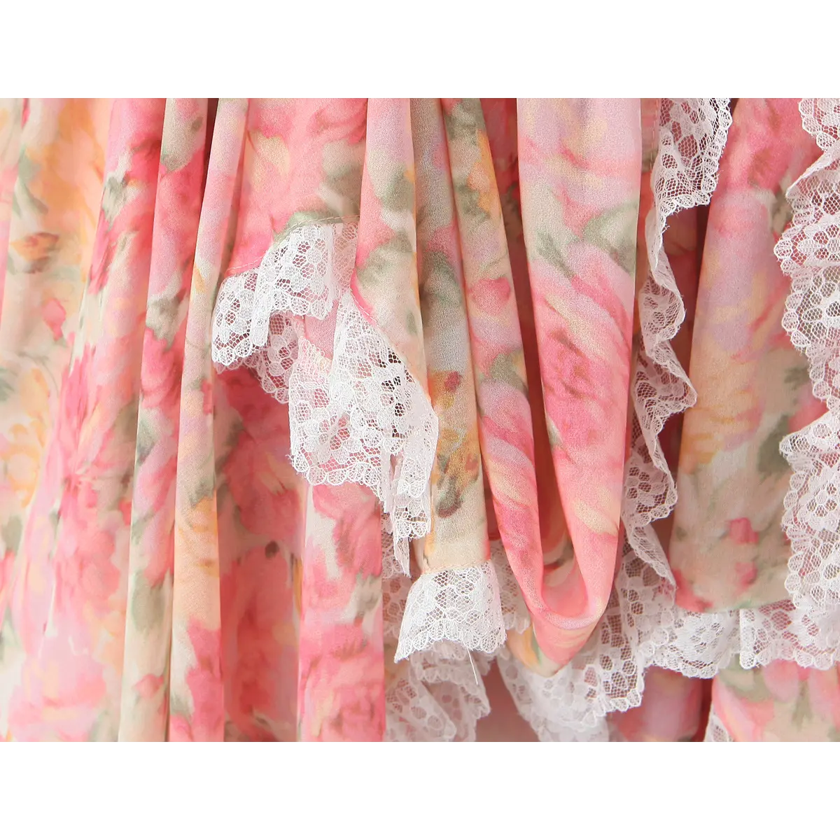 Close-up of the tiered skirt hem, showing the delicate lace trim and the flow of the lightweight chiffon fabric.