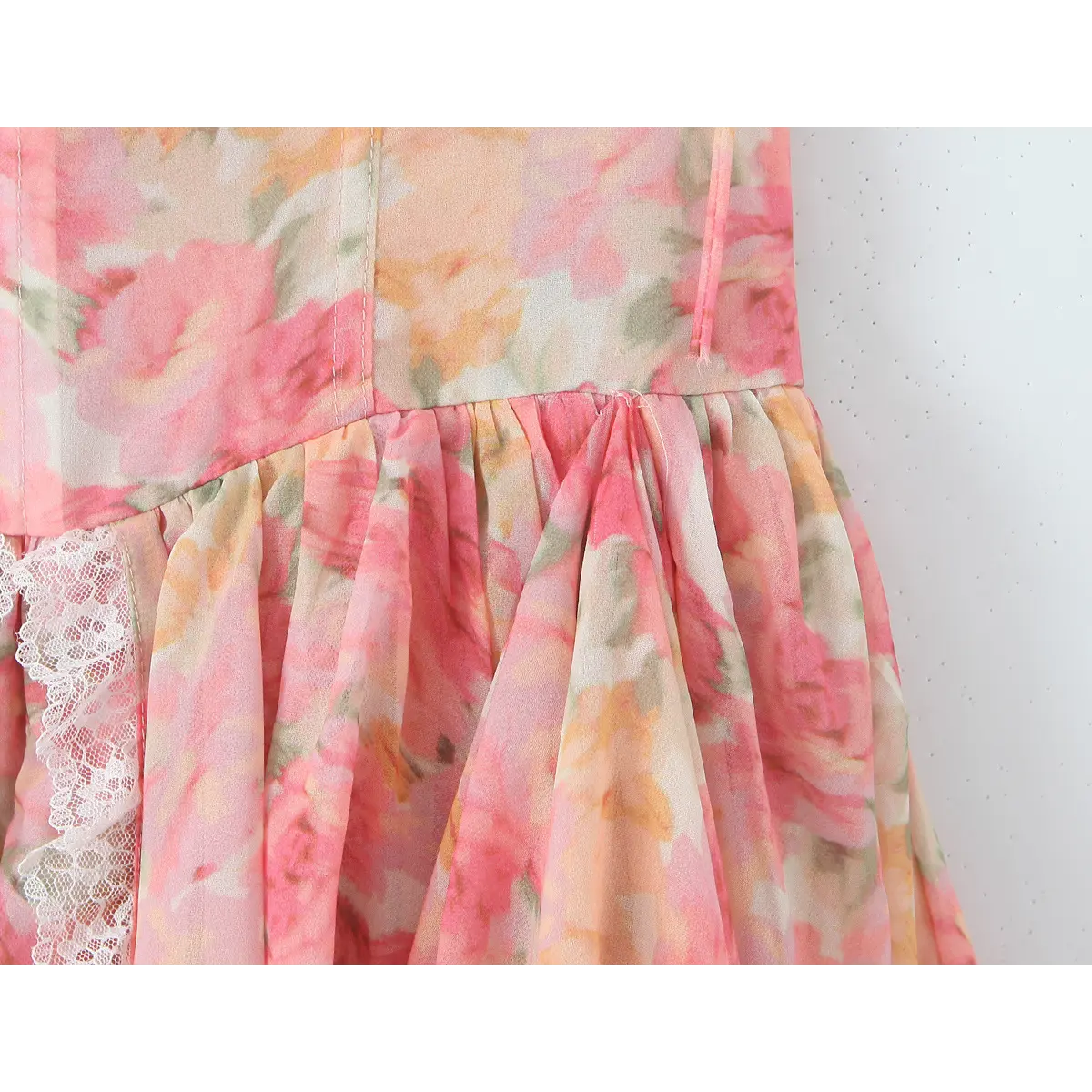 Close-up of the structured waist seam where the corset-style bodice meets the gathered tiered skirt.