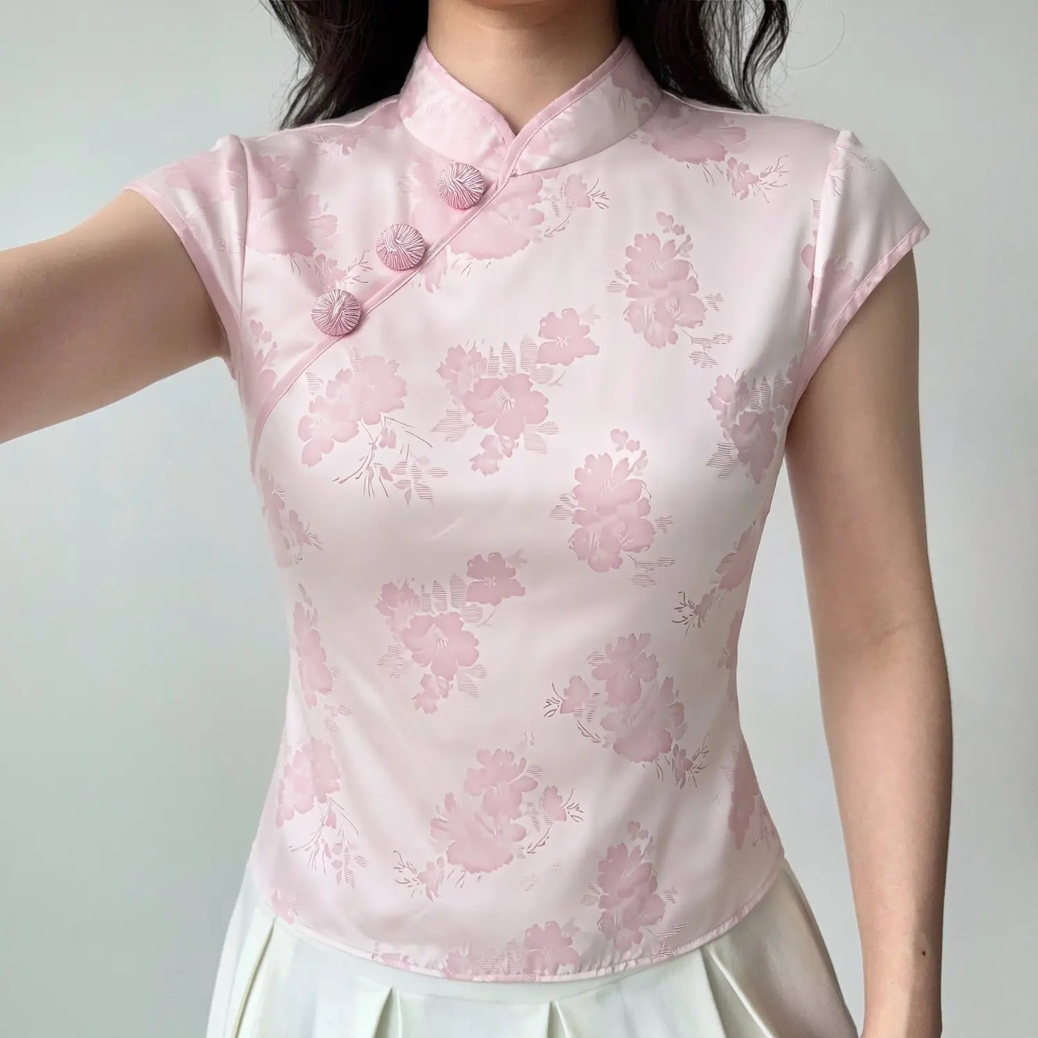 Front lifestyle shot on model, mandarin stand collar diagonal frog button floral jacquard top, matched with white pleated skirt, new chinese casual outfit
