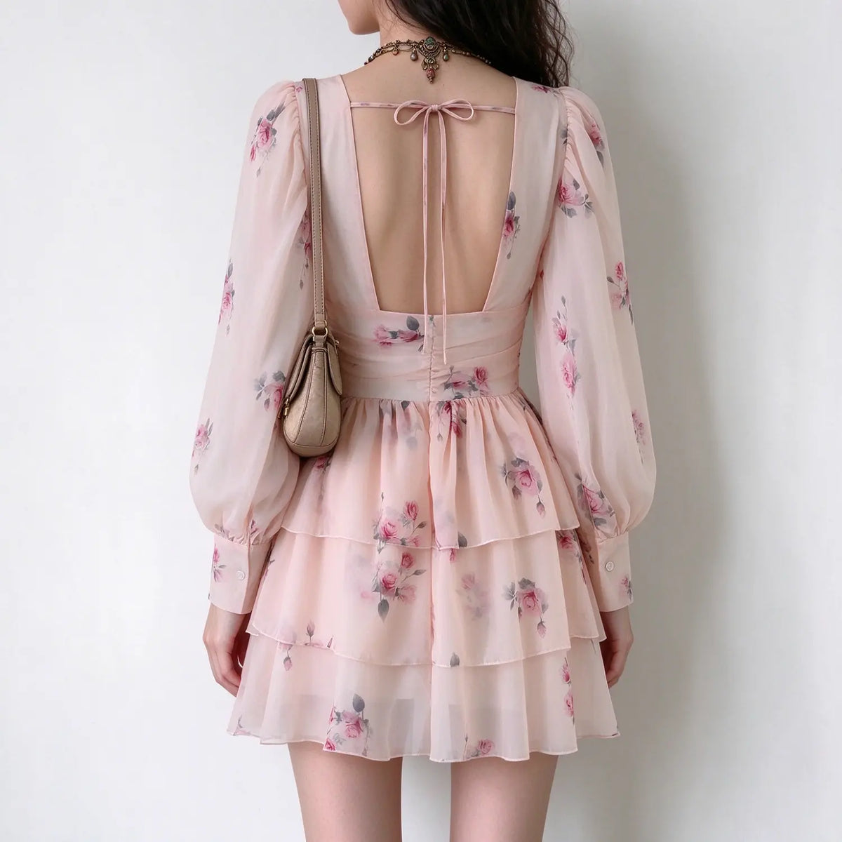 Back view of pink floral chiffon mini dress, open back with tie string, ruched back waist, balloon long sleeves, tiered ruffle skirt