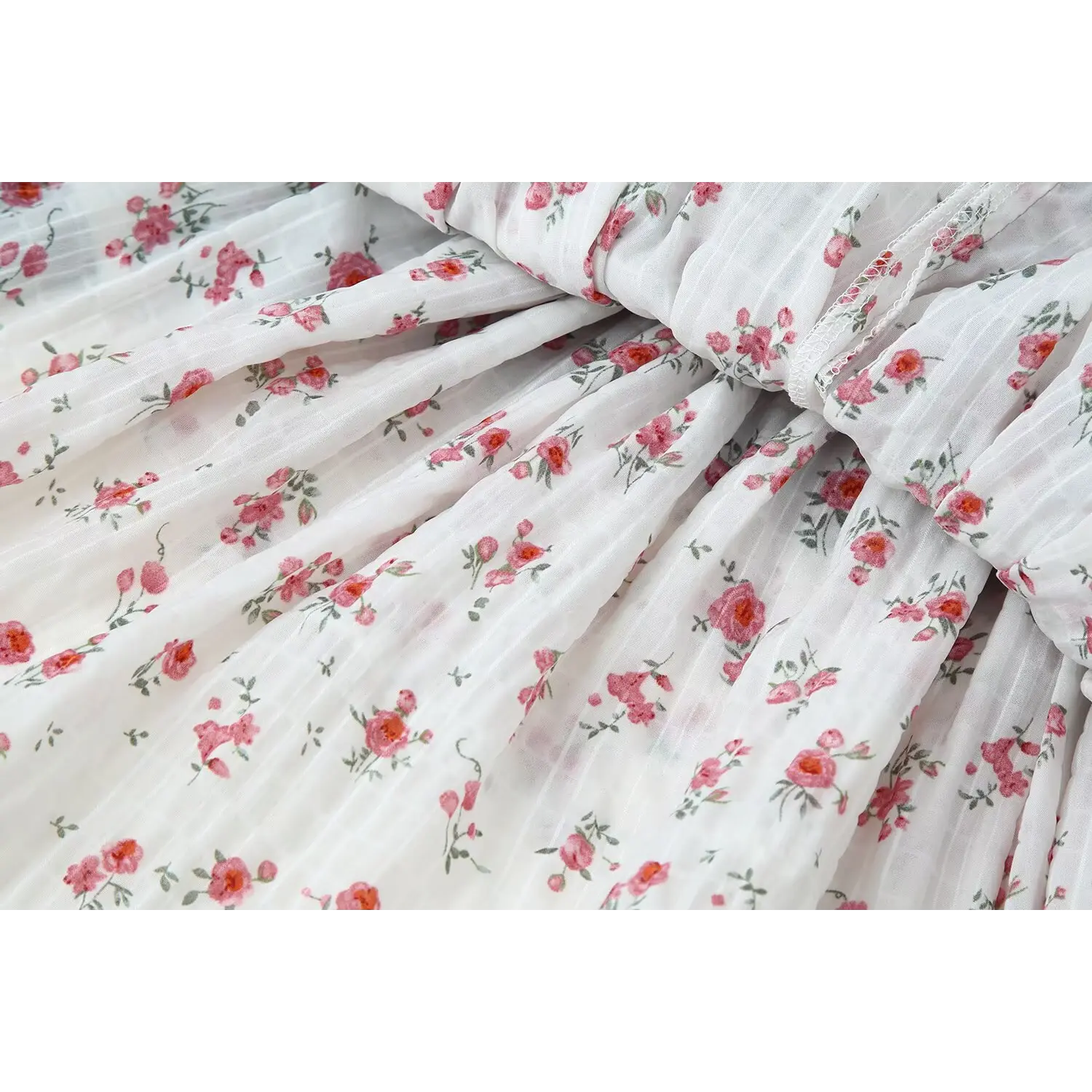 Close‑up of white base pink rose floral chiffon fabric, tiered skirt textile print detail