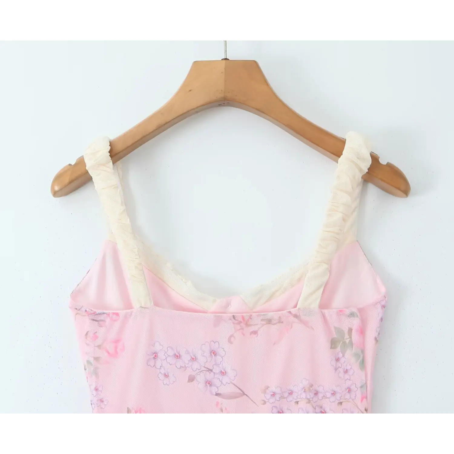 Close‑up back neckline and cream ruched cami straps of pink rose printed mesh mini dress