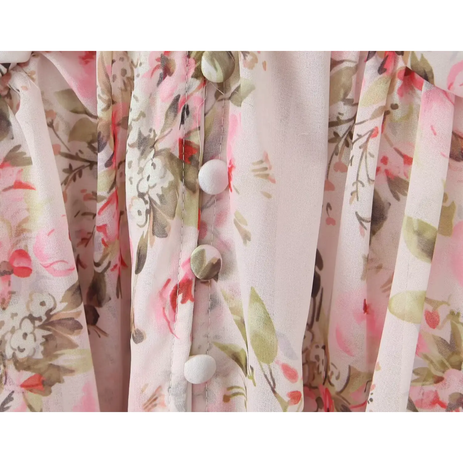 Macro close‑up of fabric covered front buttons on pink floral chiffon mini dress