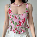 Model wearing pink floral fruit print sleeveless ruffle hem crop top