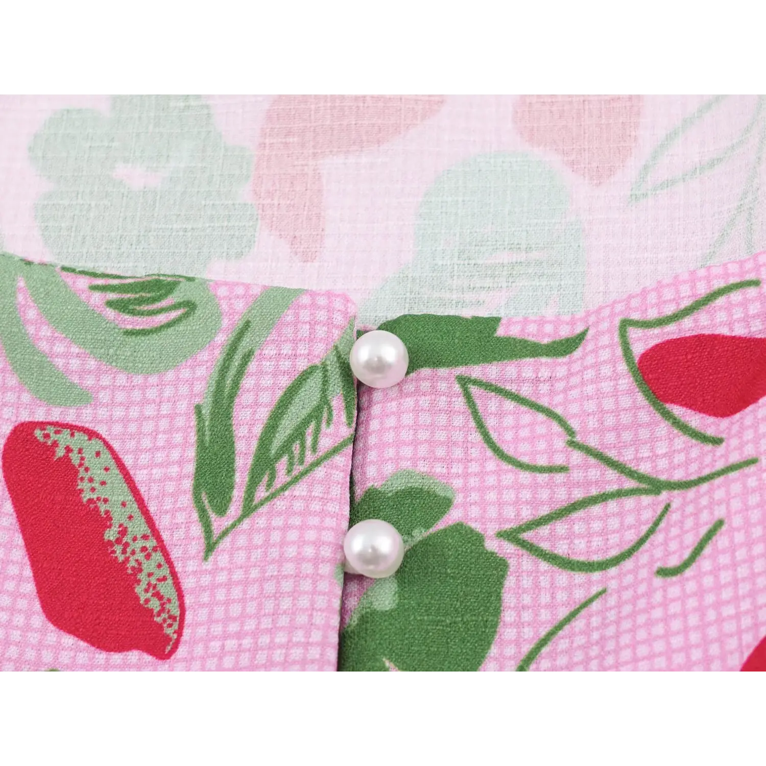Close-up of front pearl buttons on pink floral fruit print sleeveless crop top