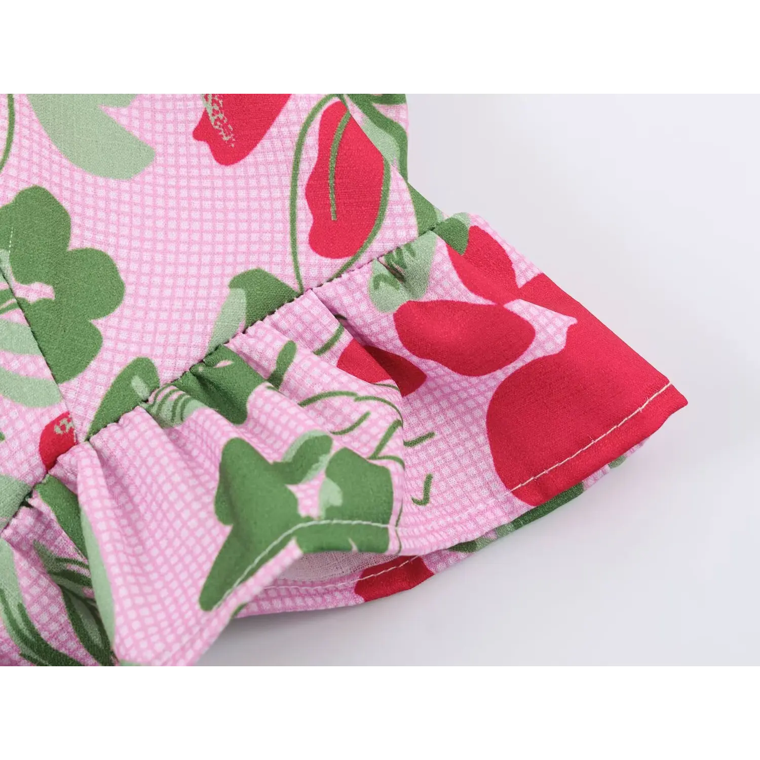 Close-up of ruffle hem stitching on pink floral fruit print sleeveless crop top