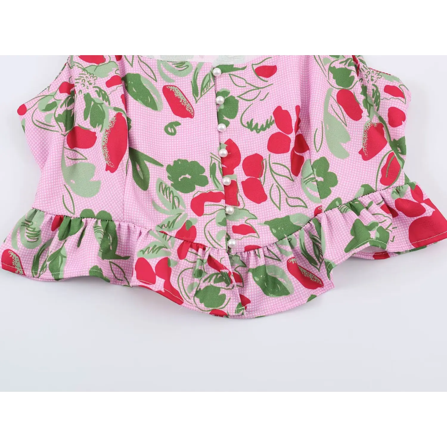 Front ruffle hem overview of pink floral fruit print sleeveless crop top