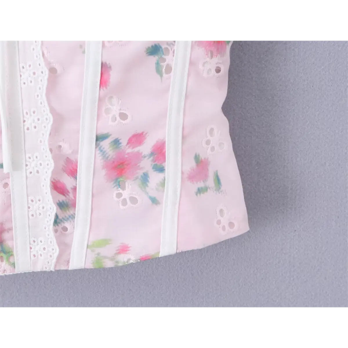 Close-up of the corset-style boning and scalloped neckline on the pink floral cami top