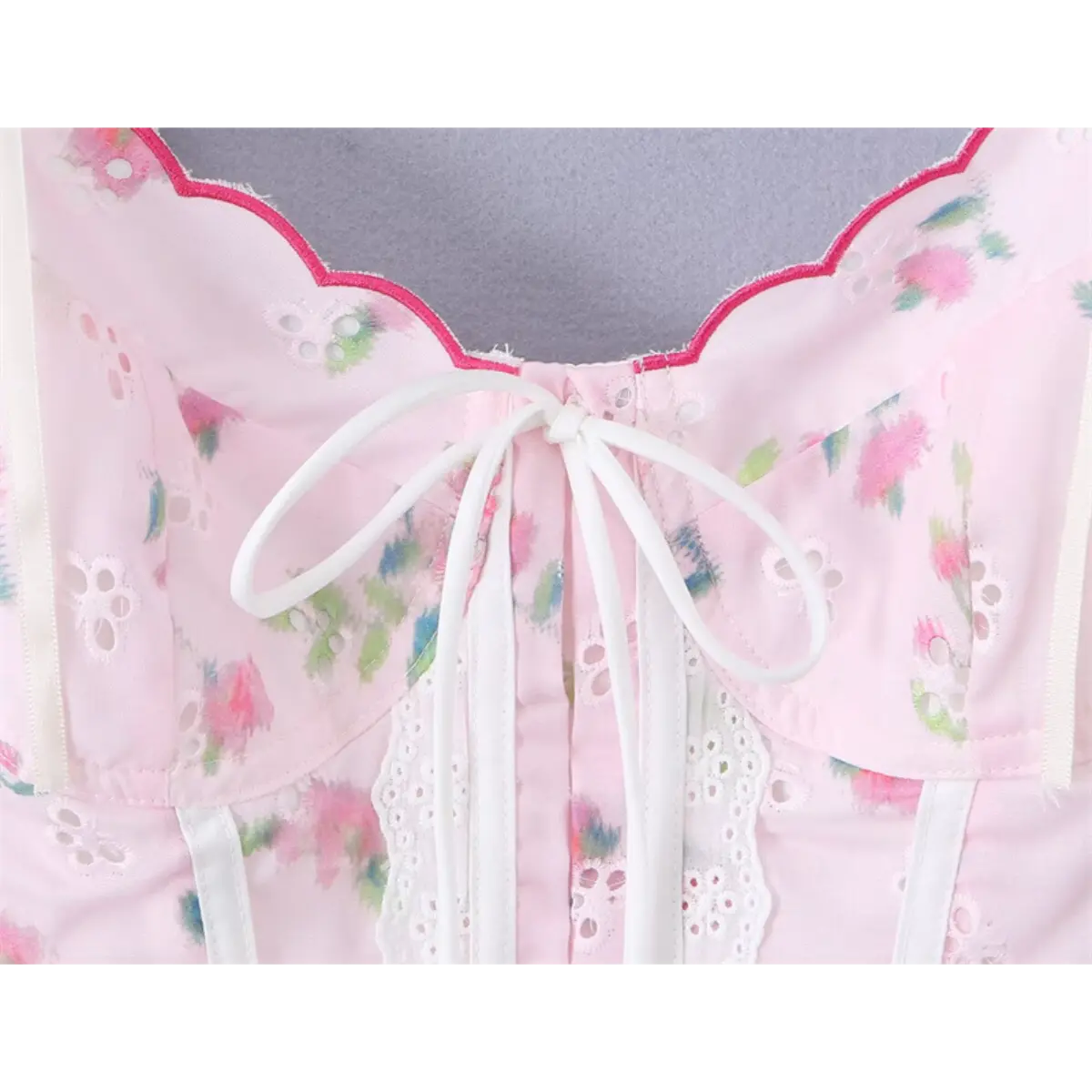 Close-up of the front bow and keyhole detail on the pink floral lace cami top