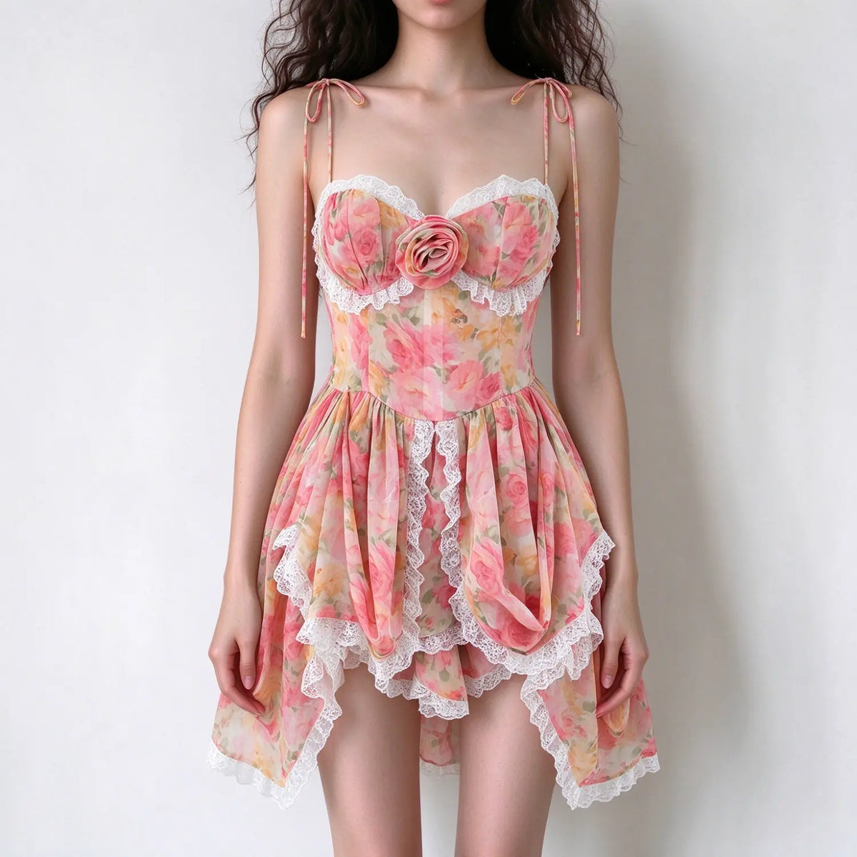 Model in pink floral corset mini dress, 3D rose bust detail, white lace trim, irregular ruffle hem, tie spaghetti straps