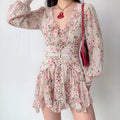 Model wearing pink floral long sleeve mini dress, v‑neck ruffle, ruched waist, tiered ruffle skirt