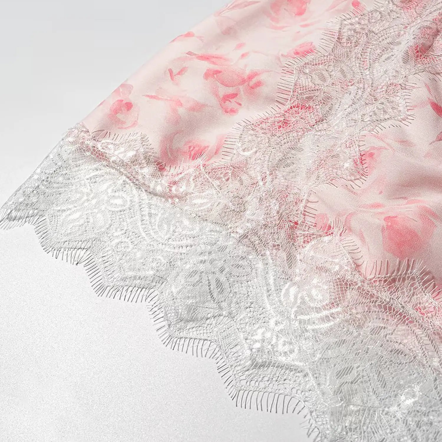 Close up scalloped eyelash lace hem of pink floral mini skirt