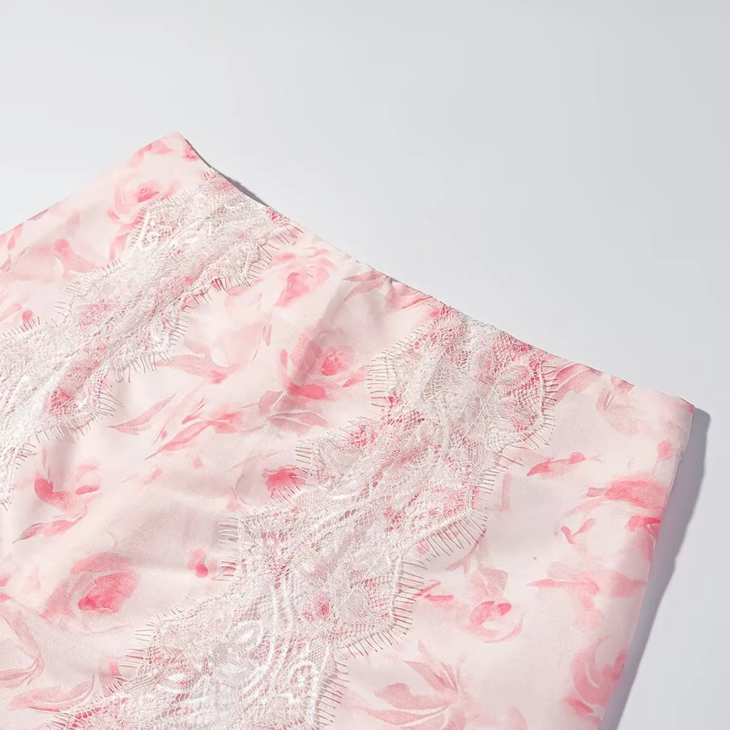 Close up vertical eyelash lace panel on pink floral satin mini skirt