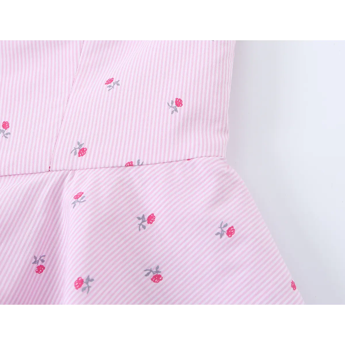 Close-up of the waist seam, showing the transition from the fitted bodice to the flared peplum hem, with the pink floral and striped print.