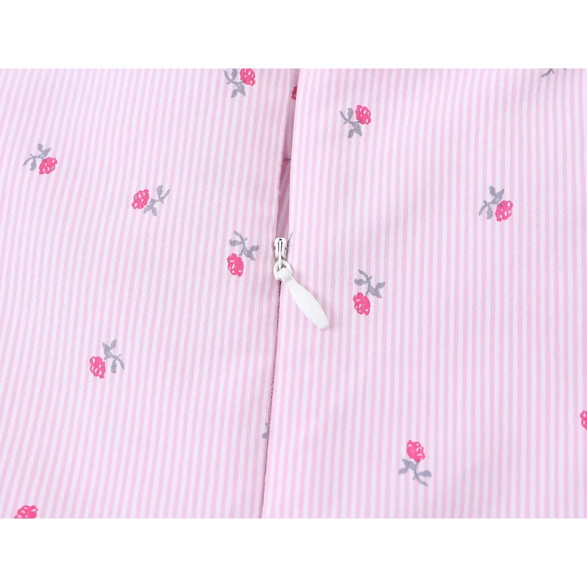 Close-up of the hidden zipper, showing the white pull tab against the striped floral fabric.