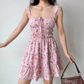 Slight angle view of the pink floral tiered dress, showing the flowy ruffled hem.