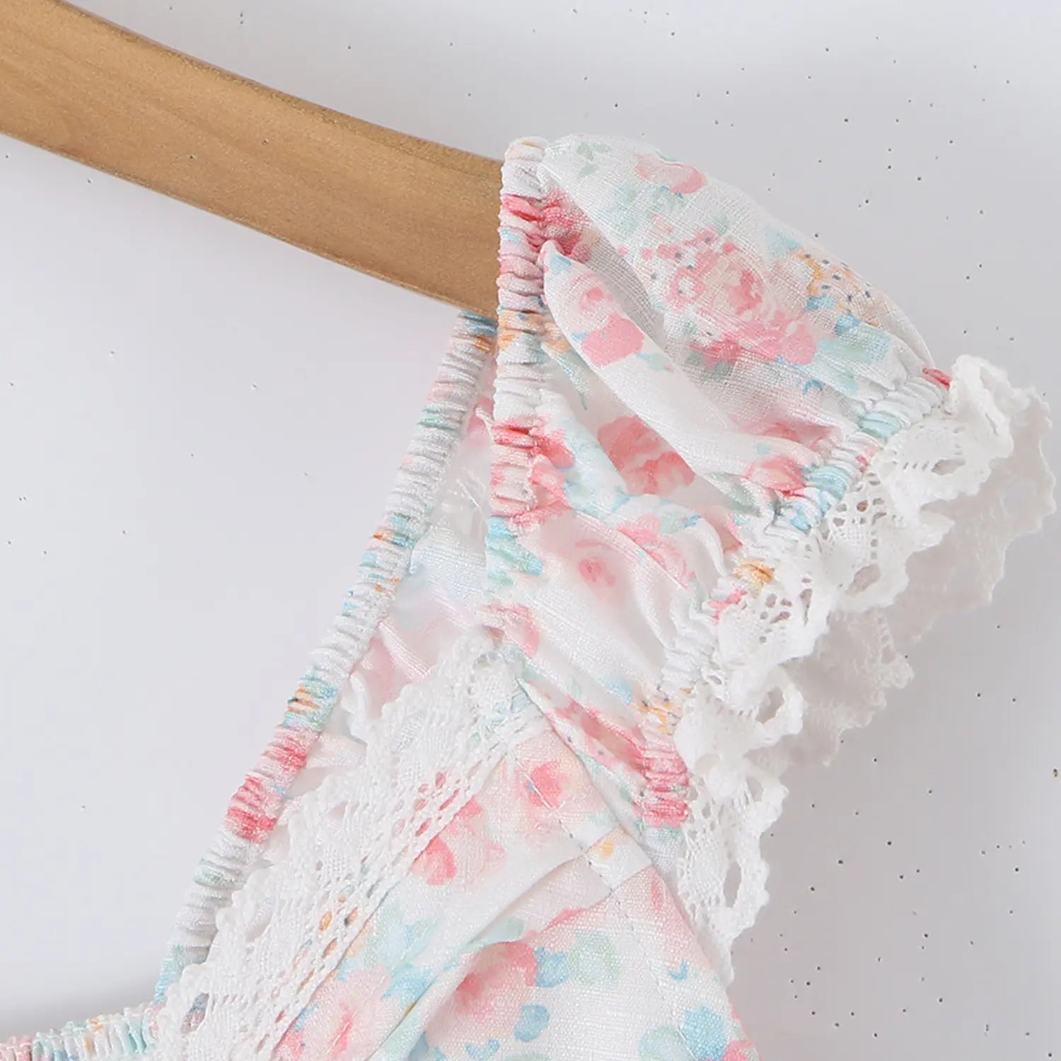 Pink floral cami top strap close-up, ruched cap sleeve hollow lace trim and stitching seam detail