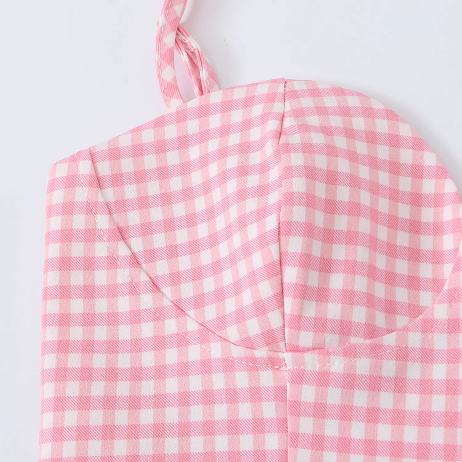 Close-up of the structured sweetheart cup seam and gingham pattern on the corset-style top