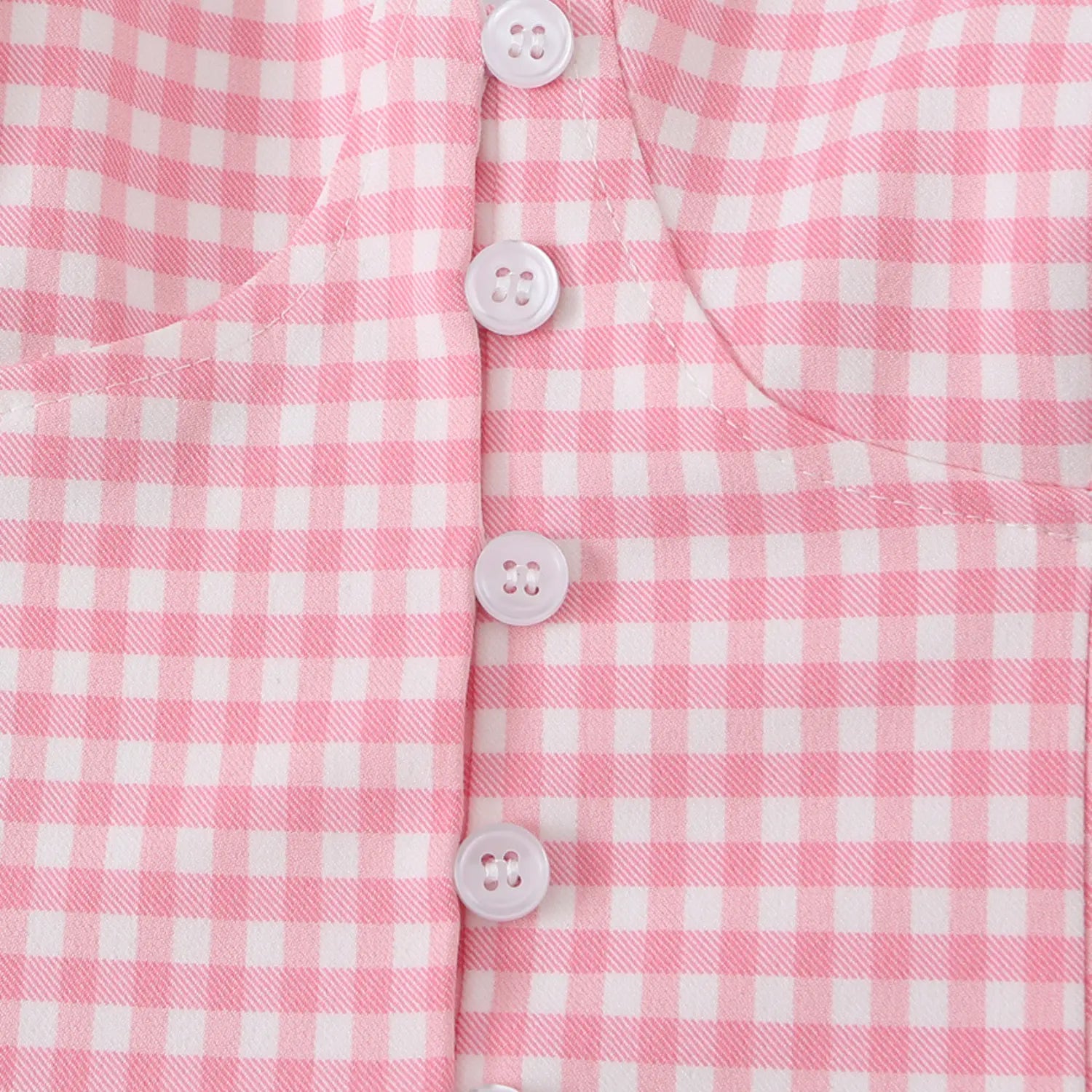 Close-up of the white four-hole buttons on the front placket of the pink gingham cami