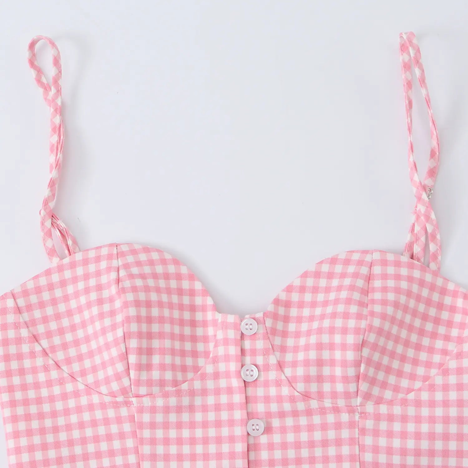 Close-up of the sweetheart neckline, front buttons, and adjustable straps on the pink gingham top