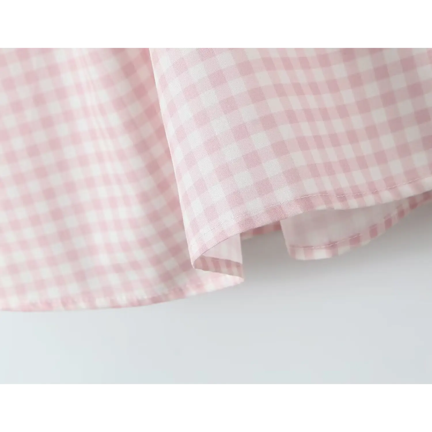 Extreme close‑up skirt hem finished stitching pink gingham woven fabric texture