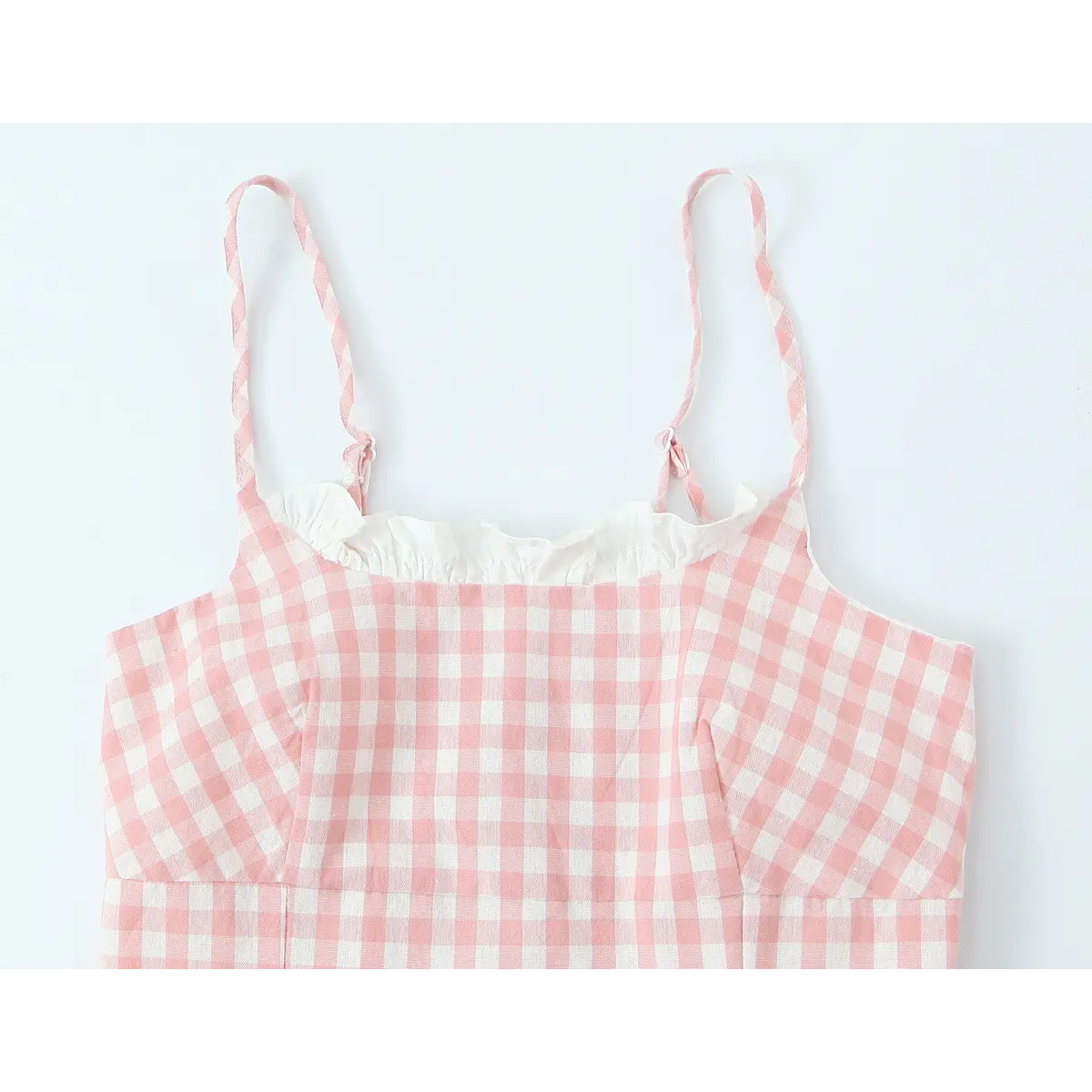 Full front view of the cami top, featuring the ruffled neckline, adjustable straps, and tailored bodice with vertical darts.