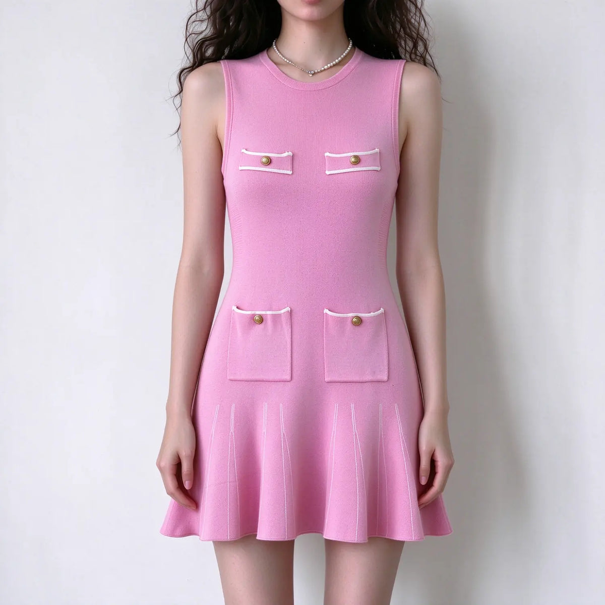 Model wearing pink gold button pocket knit sleeveless mini dress, front view