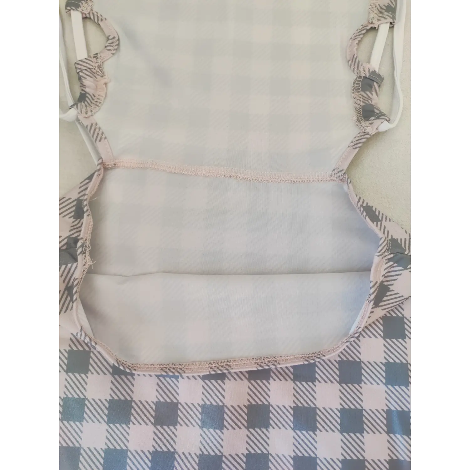 Close up view of inner stitching on pink gray checkered bodycon dress