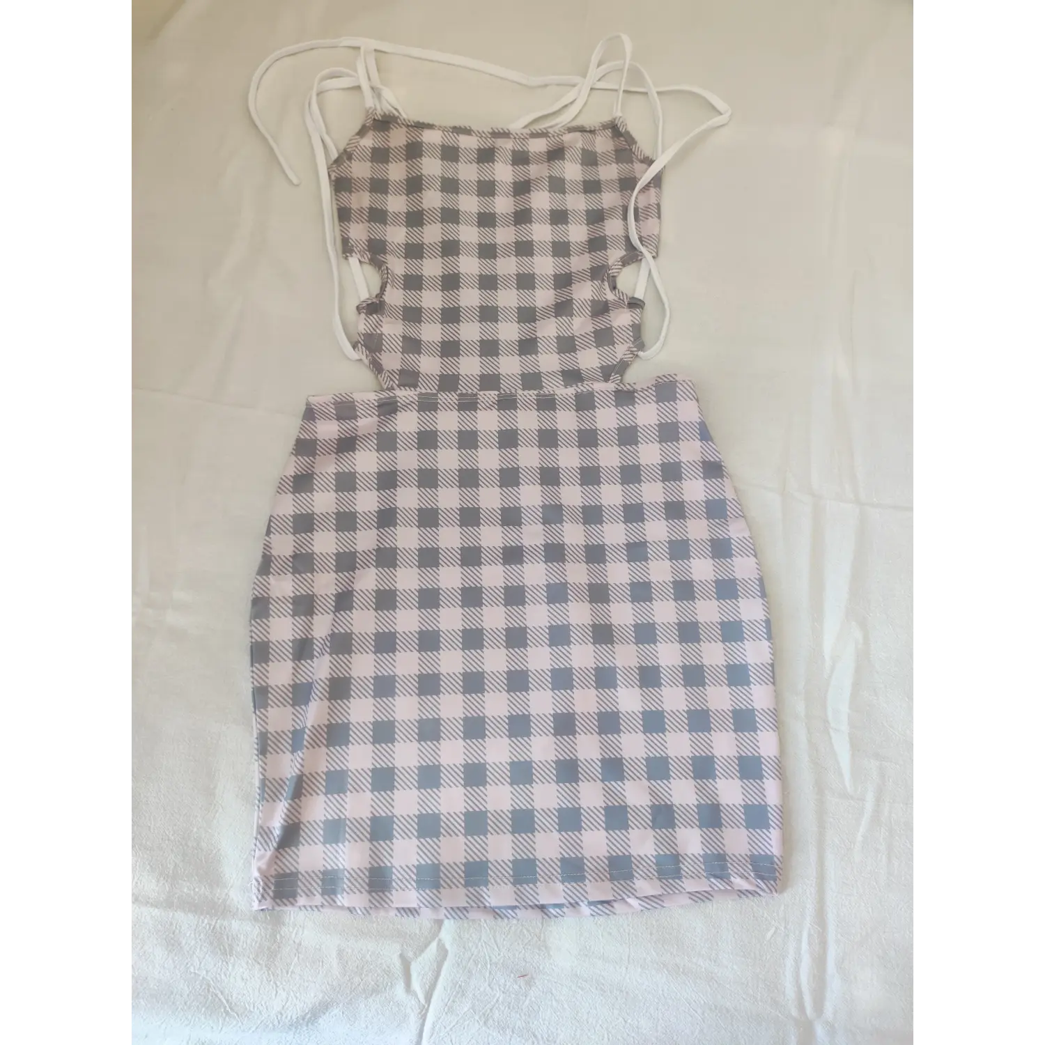 Pink and grey gingham halter mini dress with waist cutouts, flat lay front view