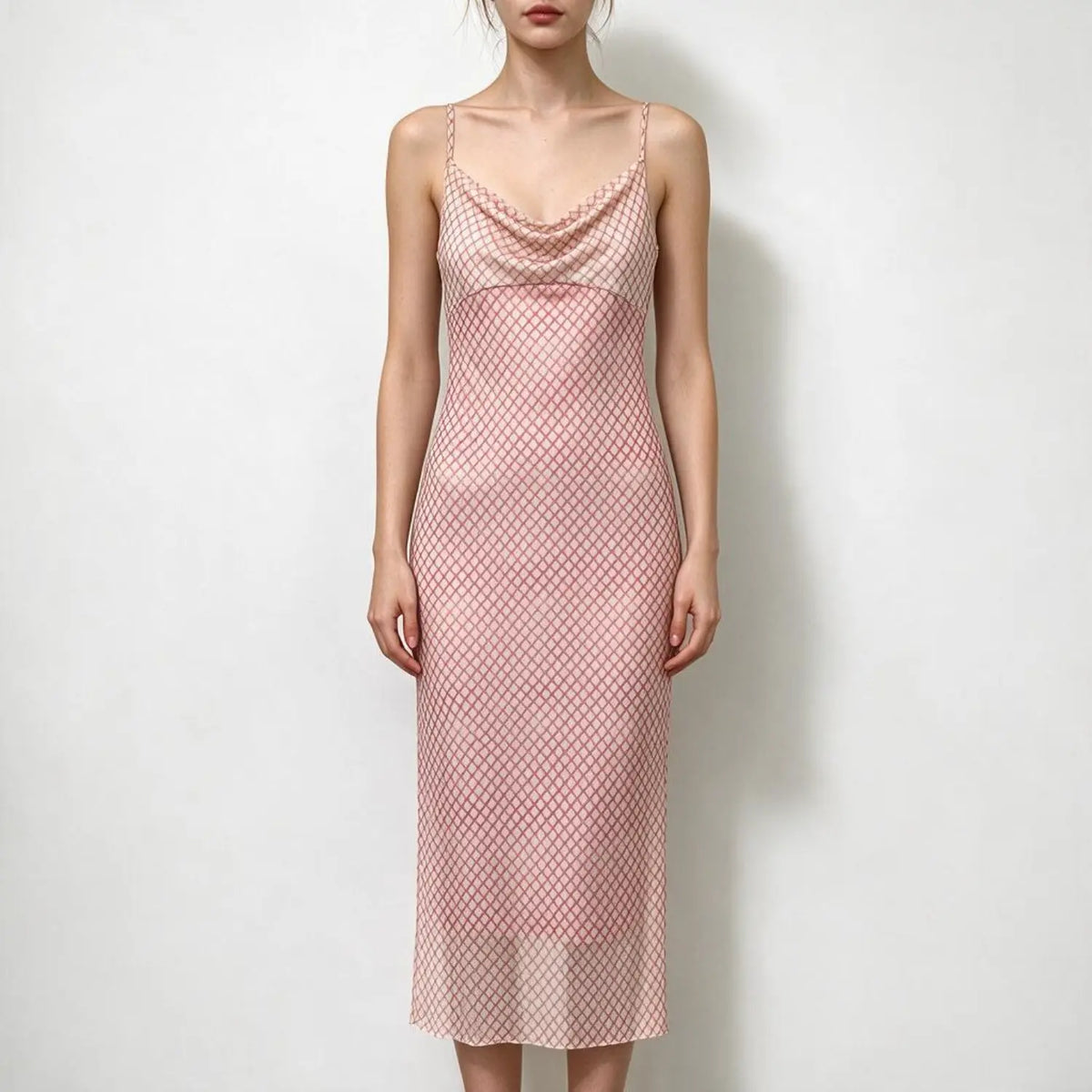Model wearing pink grid print spaghetti strap maxi dress with cowl neck, slim fit, sheer flowy skirt, plain white background