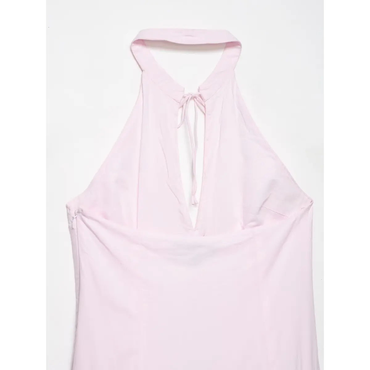 Back view of the dress, showing the halter neckline, tie, and side zippers.